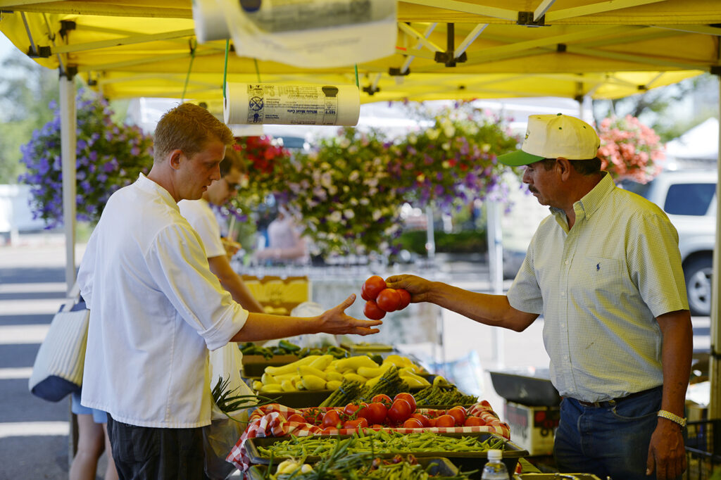 DENVER, CO - JUNE 17:   Chef Dustin Brafford of Opus a restaurant in Cherry Creek North went to the Cherry Creek Farmers Market on Wednesday June 17, 2015. Brafford, left,  buys tomatoes from Jose Gutierrez of Palizzi Farm in Brighton, CO.   (Photo by Cyrus McCrimmon/The Denver Post )